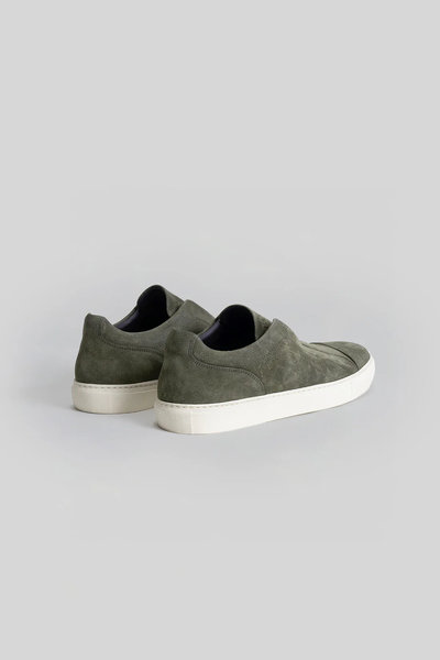 The Robert Barakett Catro Suede Sneaker by Robert Barakett, in olive green Italian suede with white rubber soles and a cushioned insole, is shown on a light gray background.