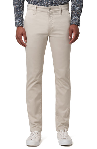 A person wearing 34 Heritage Charisma Coolmax Big & Tall Jeans by 34 Heritage, paired with a patterned dark shirt and white sneakers, stands against a plain background.
