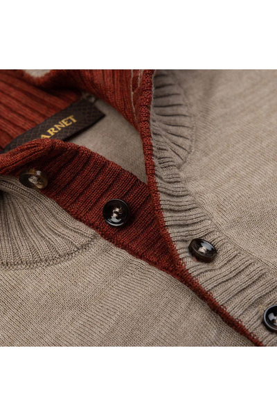 Close-up of the Garnet Sweater 24220 by Garnet: a men’s Merino wool long-sleeve with beige body, ribbed maroon collar and placket, brown buttons, and a partially visible label inside the collar.