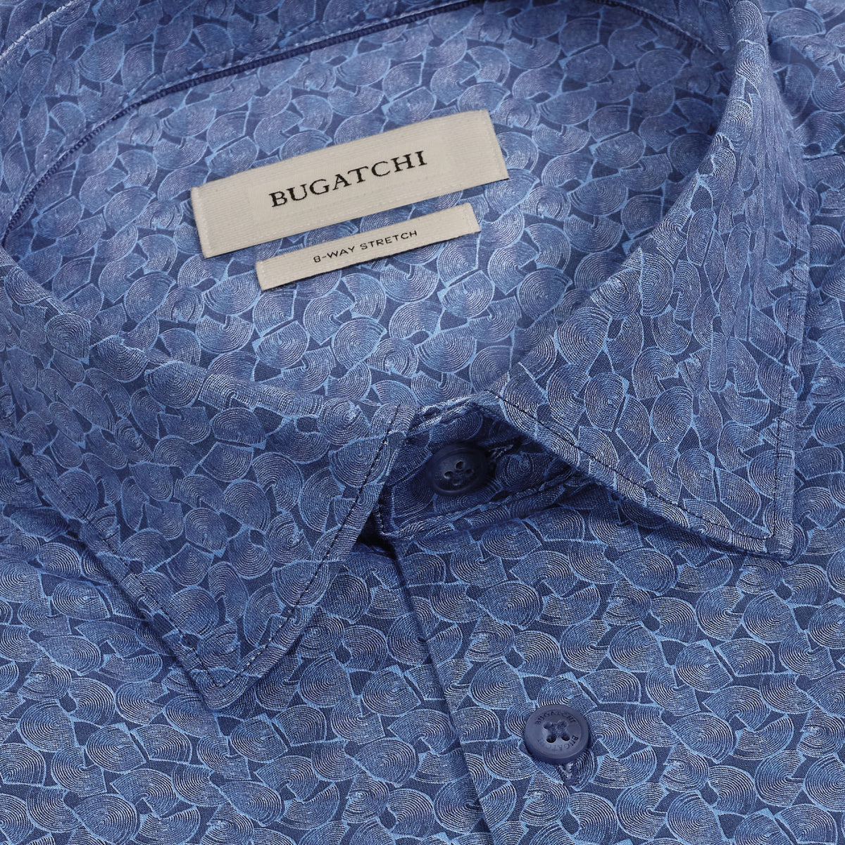 Close-up of the Bugatchi James Geometric Sport Shirt KF9188K60, a blue wrinkle-resistant shirt showcasing an abstract leaf pattern, button-down collar, and visible Bugatchi brand label.