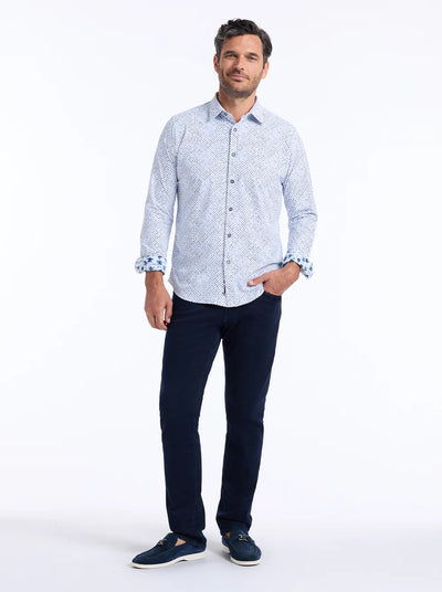 A man stands against a white background wearing the Robert Graham Montagu Knit Sport Shirt Big & Tall by Robert Graham, paired with dark pants and dark shoes.