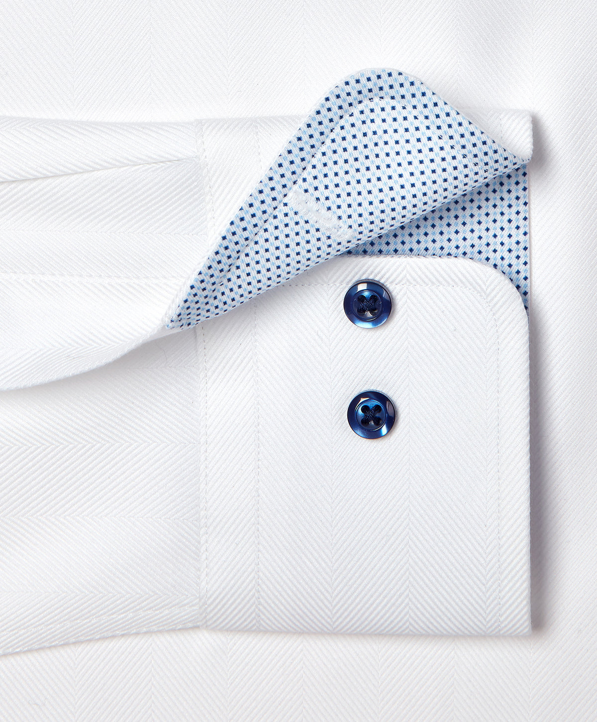 Close-up of the David Donahue Contrast Herringbone Solid Dress Shirt TBMS13100 cuff with two blue buttons and contrasting inner lining with a small blue dot pattern.