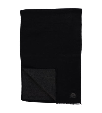 The Amanda Christensen Double Face Scarf 440714 is a rectangular black scarf with a subtle dark gray underside, elegant fringed edges, and a small black label in one corner, shown on a white background.