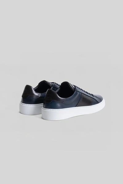 The Robert Barakett Dion Leather Sneaker by Robert Barakett in dark navy features white soles and is shown from the back and side on a plain light gray background.