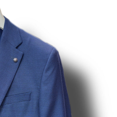Close-up of a person wearing the Jack Victor Sport Coat Blue 161150 with a lapel pin, tailored fit, and white shirt collar, set against a white background.
