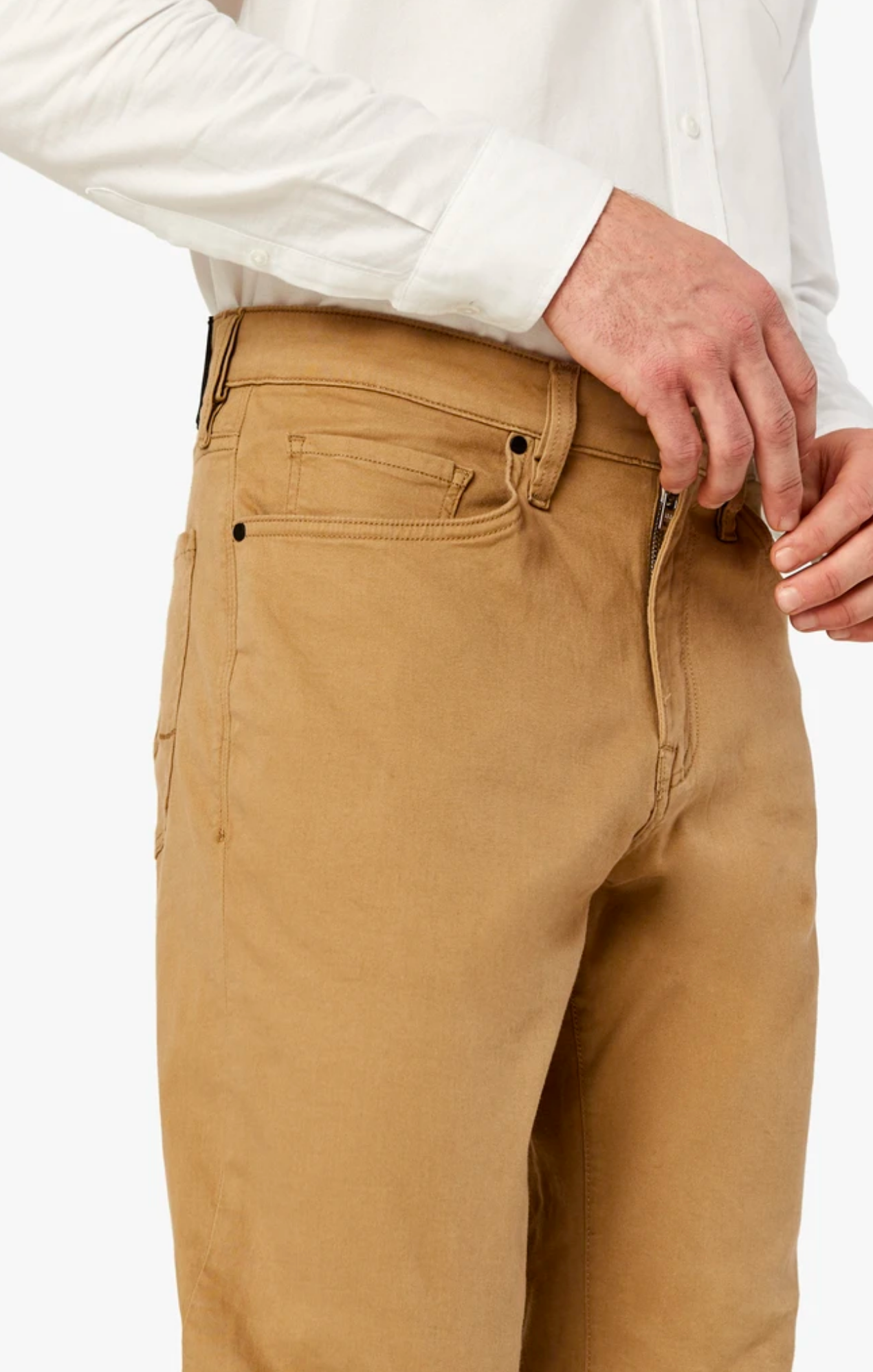 A person wearing a white long-sleeve shirt is pulling up the zipper on their 34 Heritage Charisma Khaki Twill pants by 34 Heritage.