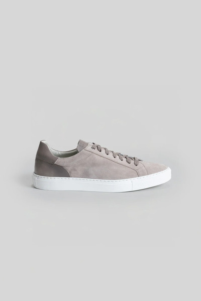 The Robert Barakett Huberto Suede Sneaker features grey suede, matching laces, a dark grey heel tab, and a white rubber sole. Photographed in profile on a light grey background. Step up your style with these luxury sneakers by Robert Barakett.