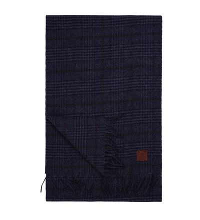 The Amanda Christensen Wool Check Scarf 440705 features a dark blue classic check pattern, fringed edges, and a brown leather patch—an elegant winter accessory from Amanda Christensen.