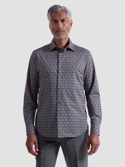 A man wearing a wrinkle-resistant Bugatchi James Leaf Print Sport Shirt (HF9221K60) and gray pants stands facing forward against a plain light background.