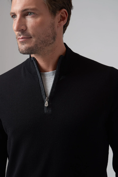 A man wearing a black Raffi Merino Zip Mock HWC19398-Z sweater over a light gray t-shirt looks slightly to the side against a plain background.