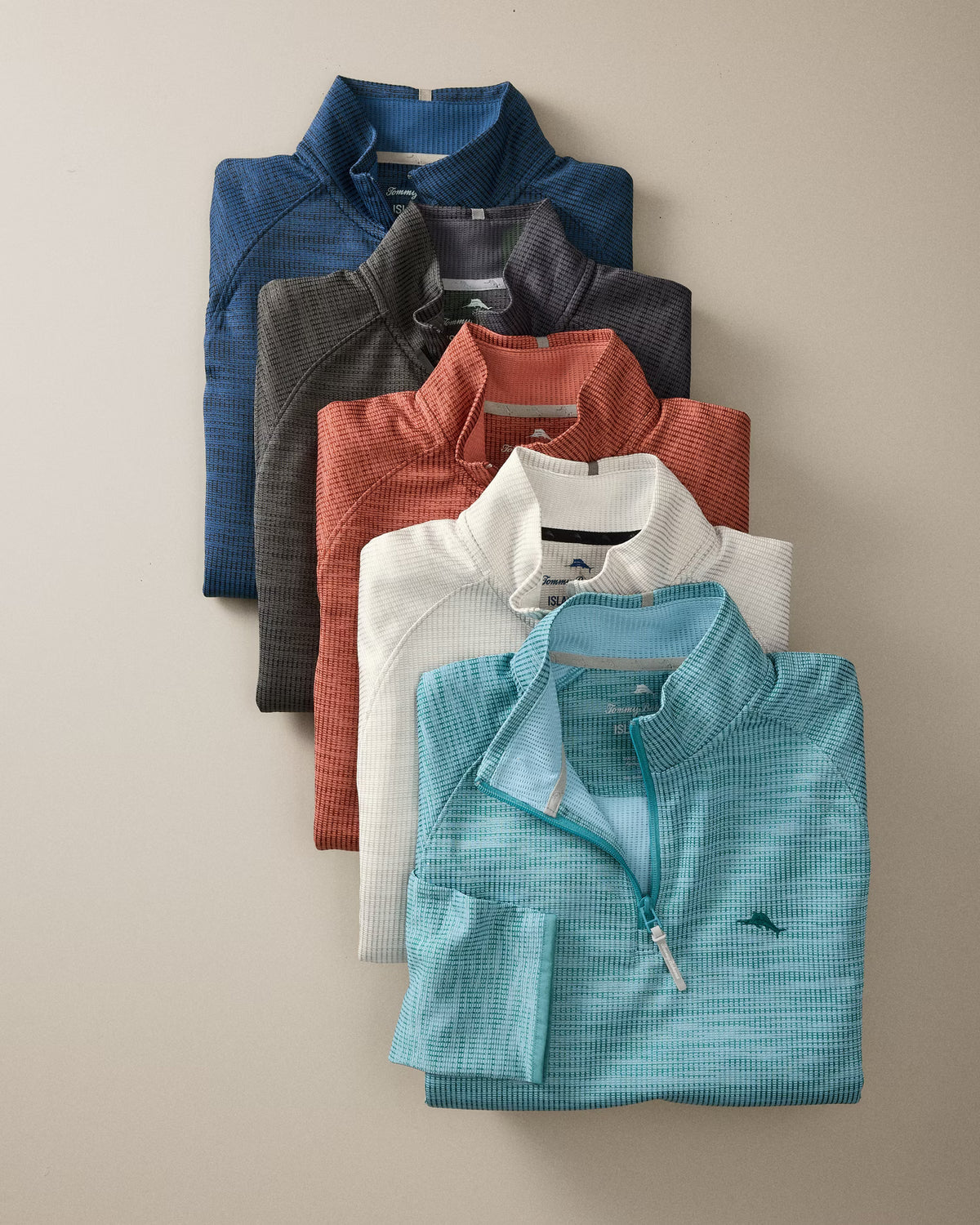 Five folded Tommy Bahama Palm Pro Half-Zip Big & Tall sweatshirts in blue, gray, orange, white, and teal stacked diagonally.