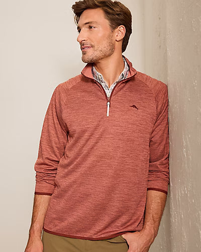A man wearing a rust-colored, textured Tommy Bahama Palm Pro Half-Zip Big & Tall Sweatshirt over a patterned collared shirt.