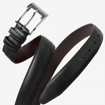 The Allen Edmonds Wide Basic Belt by Allen Edmonds is pictured coiled on a plain background, highlighting its precise stitching, carefully punched holes, and smooth black finish. Handcrafted in America from premium Italian calfskin leather, this belt embodies sophistication and timeless style with its classic silver buckle.