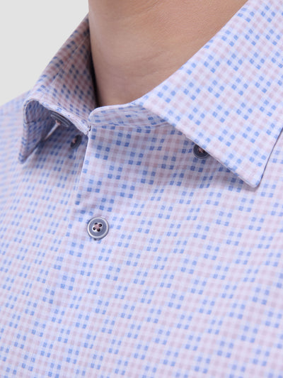 Close-up of a person wearing the Bugatchi LS Jules GF9306K65 Dusty Pink shirt, featuring a blue and pink checkered pattern and blue buttons, highlighting the refined Italian style and comfort of Bugatchi menswear.