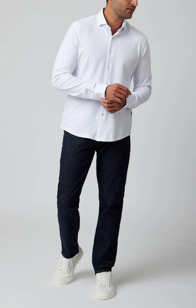 A man wearing a Stone Rose ORIGIN - Long Sleeve T-Series Sport Shirt, dark blue jeans, and white sneakers stands against a plain light gray background.