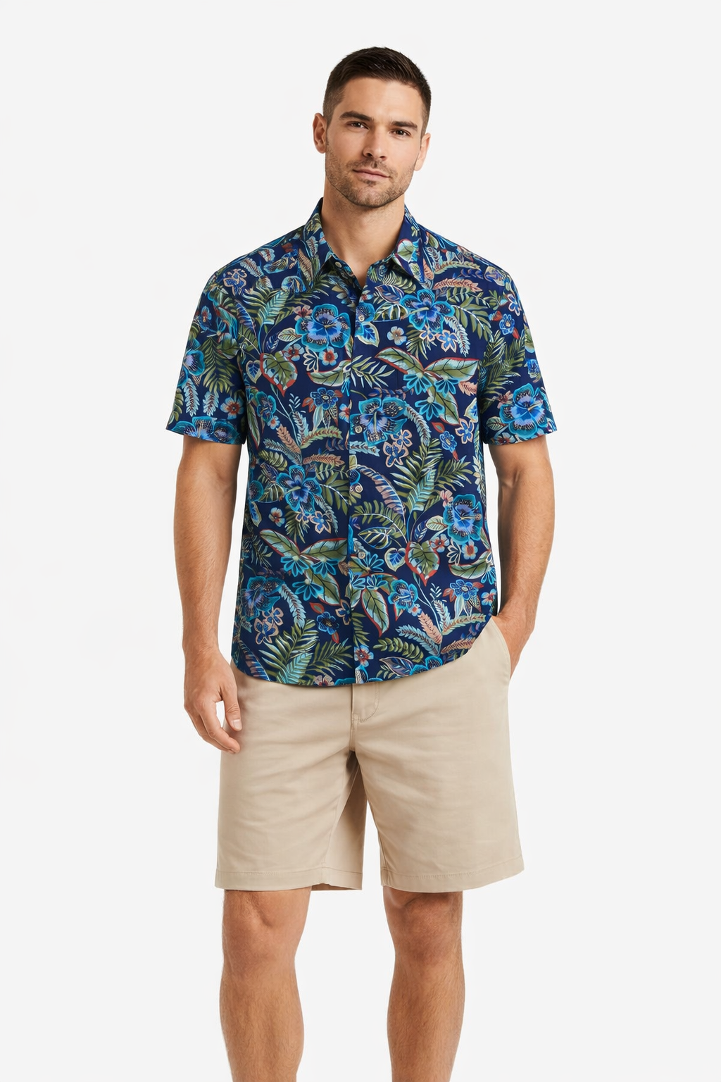 A man wears the Tori Richard Printed Cotton Flourish Shirt 1956M0329, a blue floral short-sleeve button-up by Tori Richard, paired with beige shorts, standing against a plain white background.