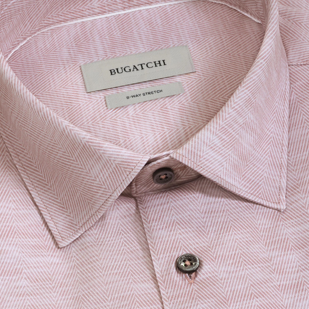 Close-up of the Bugatchi James Herringbone Sport Shirt KF9508K60 in pink, featuring a subtle herringbone pattern, detailed collar and buttons, and a brand label reading Bugatchi. This sport shirt combines sophisticated style with the comfort and flexibility of performance fabric.