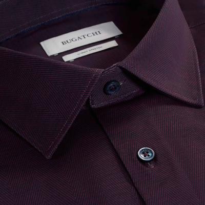 Close-up of the Bugatchi James Herringbone Sport Shirt HF9508K60 in maroon, featuring a wrinkle-resistant herringbone pattern, buttoned collar, and visible Bugatchi brand label inside the collar.