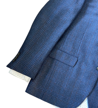 A close-up of the Jack Victor Plaid Sport Coat 1252106 showcases its blue and black Italian wool, front pocket, buttoned cuff, and a white shirt sleeve underneath.