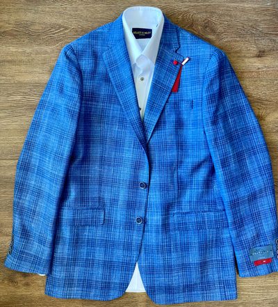 The TailoRed Gianni Sport Coat 8130534, a blue plaid men’s blazer, is displayed flat over a white dress shirt on a wooden surface, with TailoRed tags attached to the sleeve and lapel.