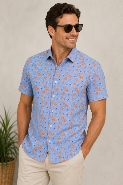 A man wears the Luchiano Visconti Floral Print Shirt IGTPPS54 with sunglasses, standing with his hands in the pockets of his tan chinos.