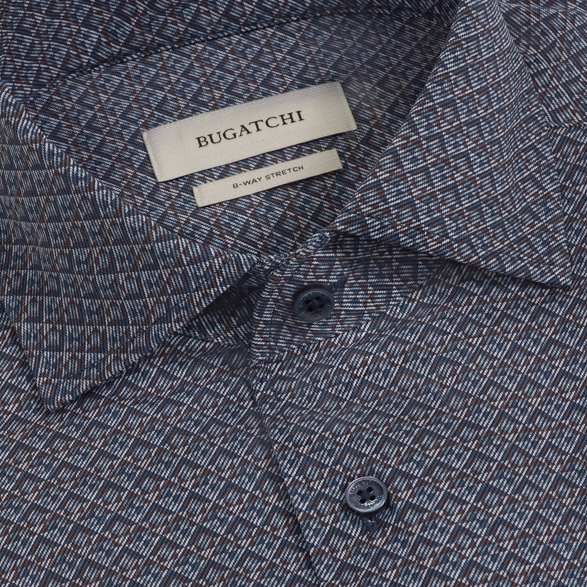 Close-up of a patterned blue Bugatchi Devon Geometric Sport Shirt (KF9431K80) featuring a visible collar, two buttons, and a label reading BUGATCHI and 8-WAY STRETCH. Crafted from wrinkle-resistant performance fabric, this shirt offers both style and comfort for any occasion.