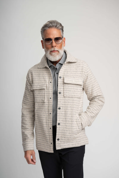 A man wearing a Stone Rose Hunter Knit Houndstooth Jacket over a grey polo shirt and sunglasses.