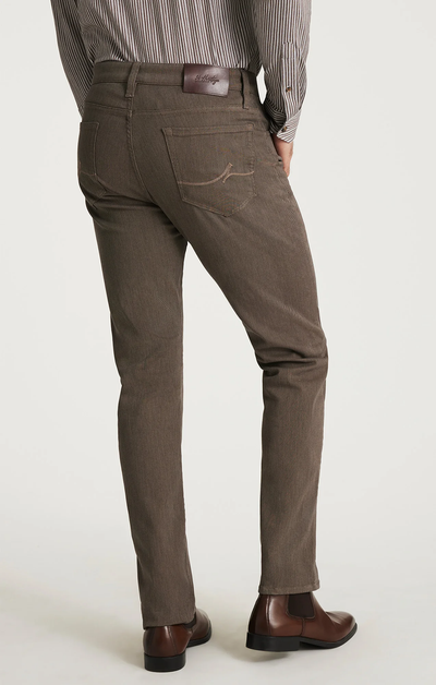 A person is shown from the back, standing against a plain light background, wearing 34 Heritage Courage Diagonal Pants in coffee color, paired with a striped shirt and brown dress shoes.