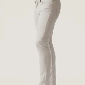 A person modeling the 34 Heritage Courage Cross Twill pants by 34 Heritage—straight-leg, light-colored twill trousers with a belt—is photographed from the waist down against a plain background.
