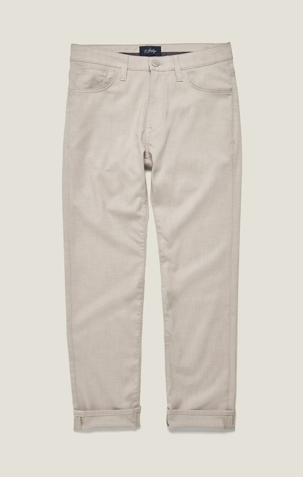 The 34 Heritage Courage Cross Twill pants by 34 Heritage are light beige, straight-leg trousers crafted from breathable twill fabric, featuring rolled cuffs, front and back pockets, and a button-zip closure, shown laid flat on a neutral background.