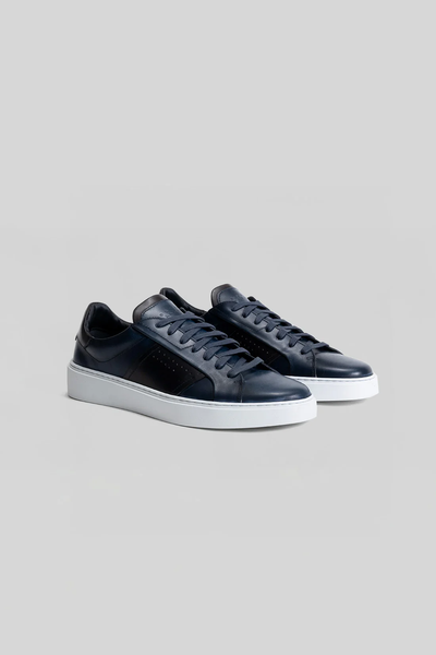 The Robert Barakett Dion Leather Sneakers by Robert Barakett in navy blue premium leather with white soles are displayed side by side on a plain grey background.