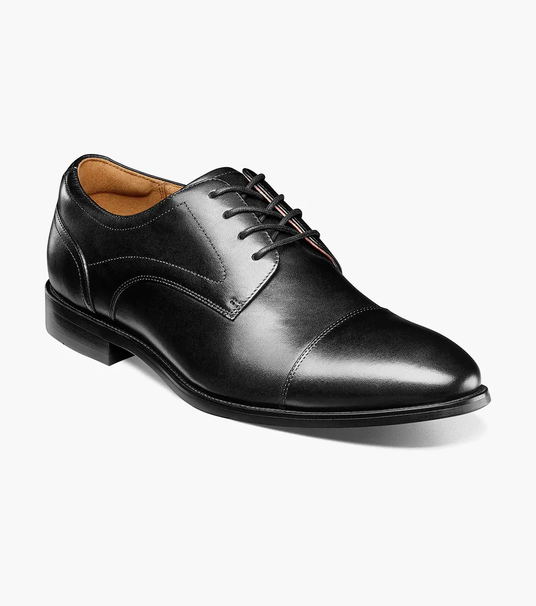 The Florsheim Rucci Plain Toe Oxford, a men’s black leather dress shoe with laces and a slight heel from Florsheim, is shown on a white background.