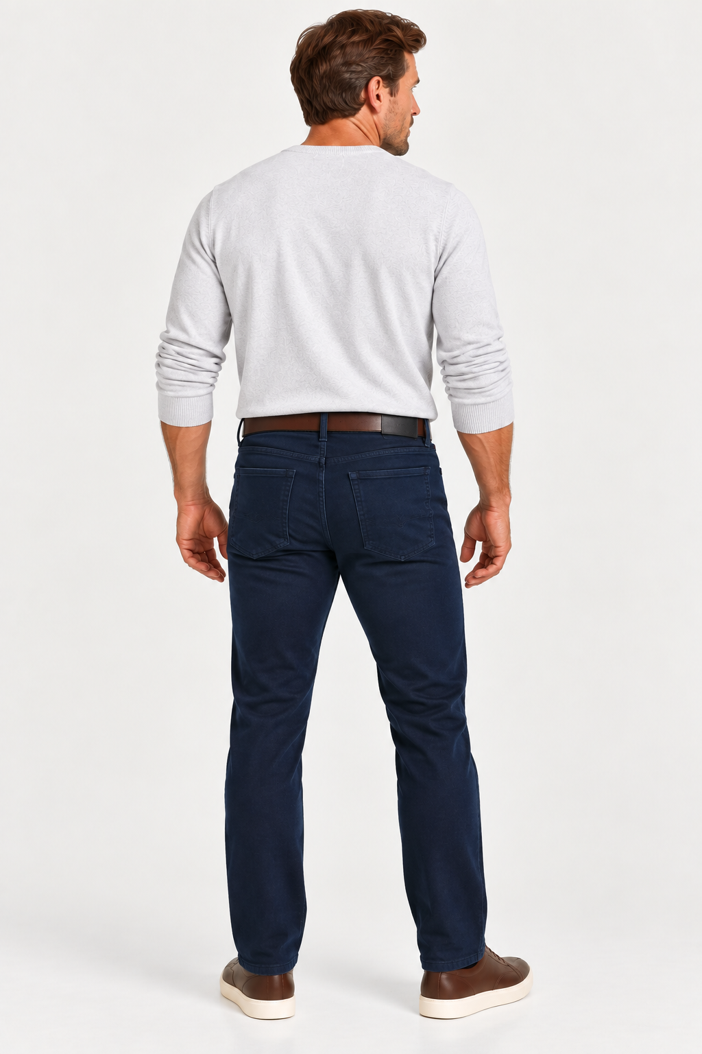 Man standing with his back to the camera, wearing a light gray top, Alberto PIPE 1607 Diamond Brushed Stretch Cotton Jeans, brown belt, and sneakers against a white background.