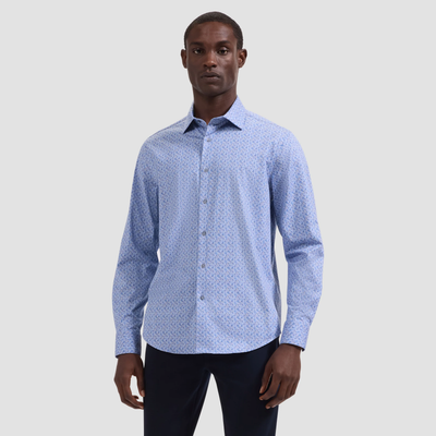 Man wearing a light blue patterned shirt on a gray background