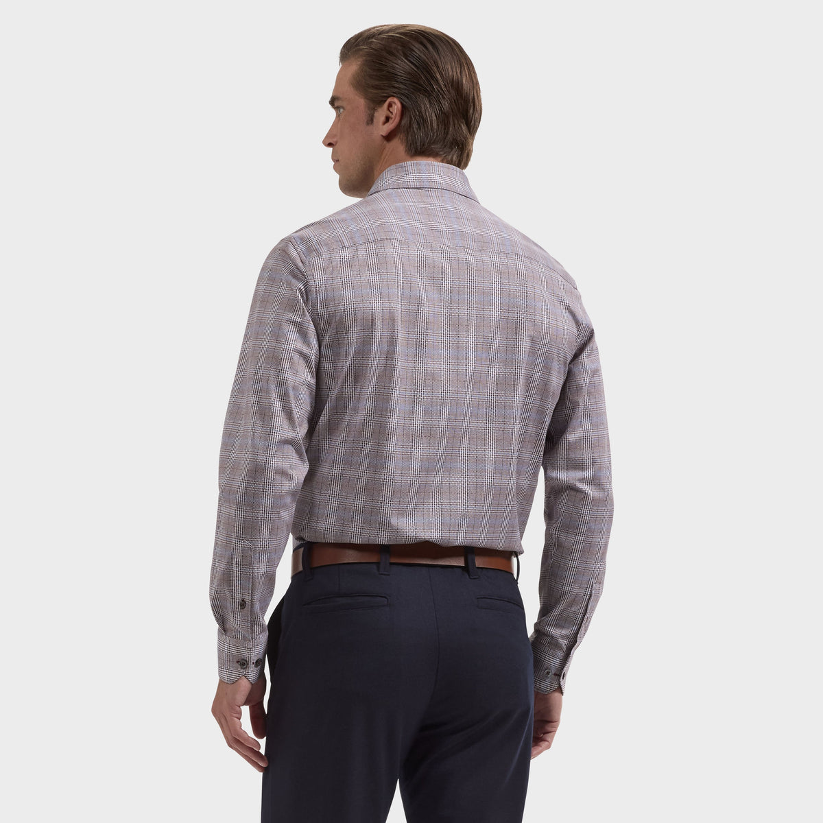A man stands with his back to the camera, wearing the Bugatchi James Plaid Sport Shirt KF9278K60—a long-sleeve, wrinkle-resistant plaid shirt from Bugatchi—paired with dark trousers against a plain light background.