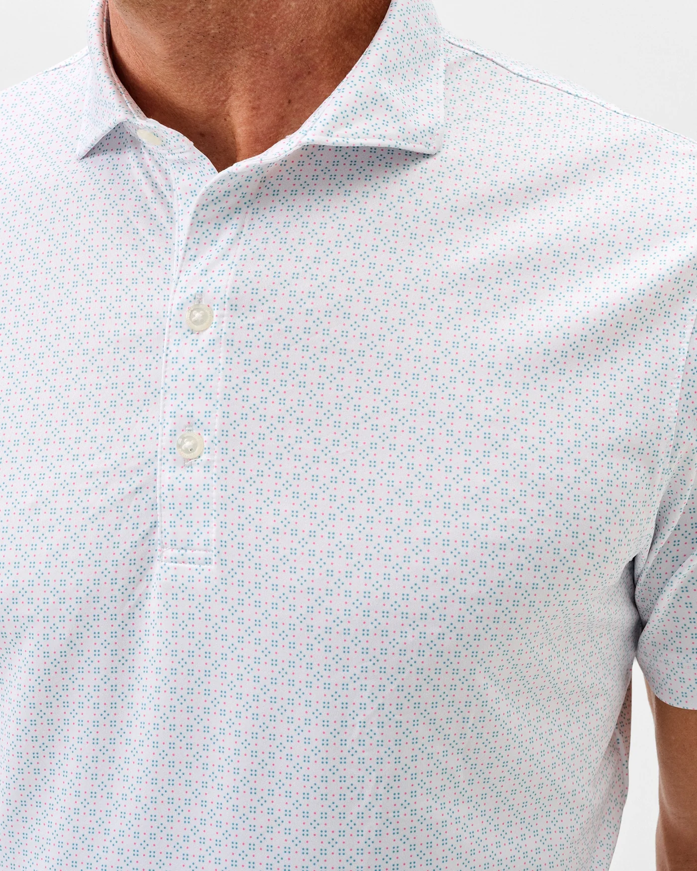A man wearing the Johnnie-O Torres Performance Big & Tall Polo—a light-colored, short-sleeve shirt with a small geometric pattern by Johnnie-O, made from moisture-wicking fabric.