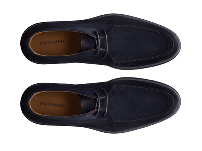 Top view of a pair of Magnanni Lello Suede Chukka Boots in dark blue, featuring tan leather insoles, displayed side by side on a white background.