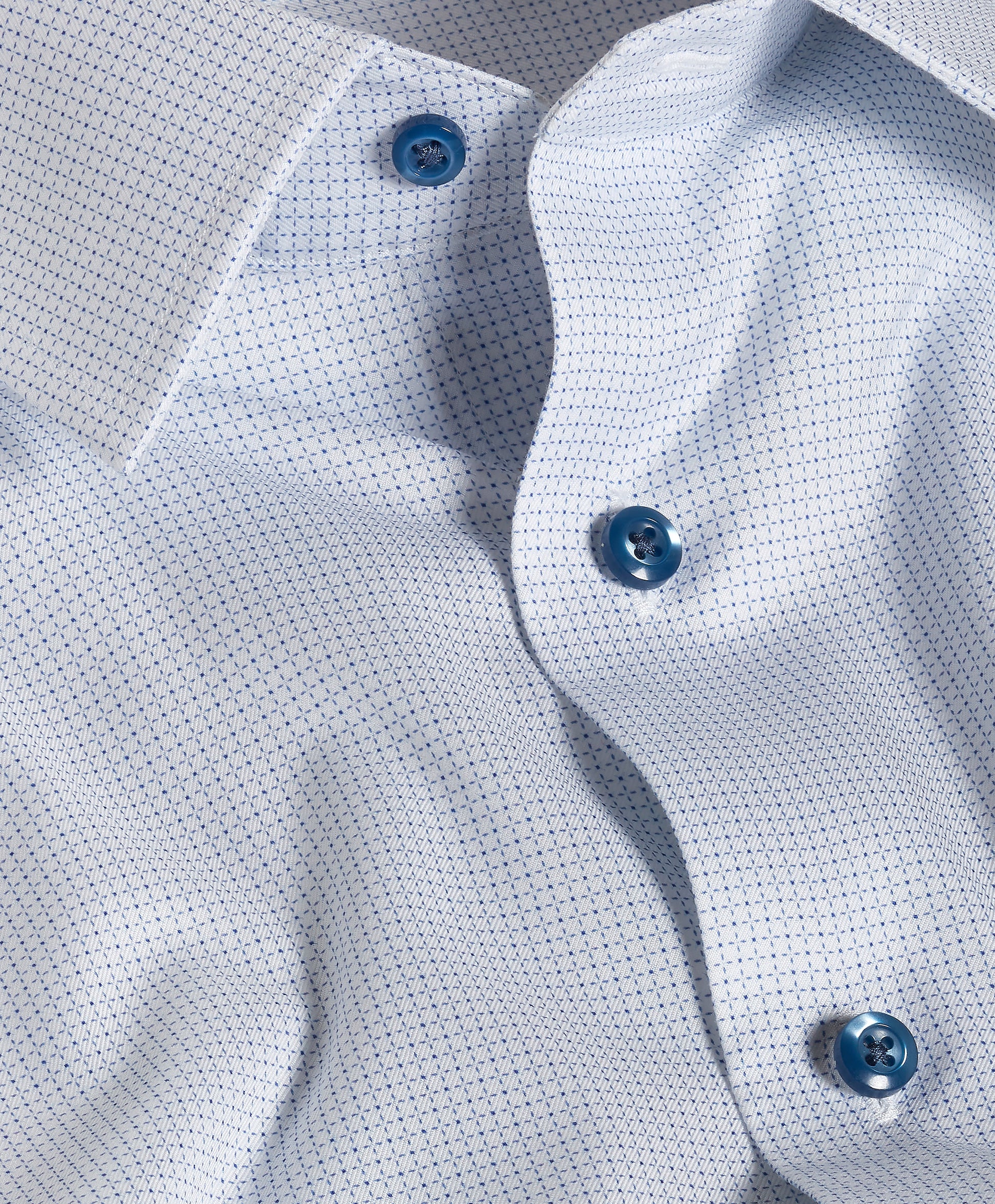 Close-up of the David Donahue Stretch Pima Dress Shirt TBSP13005 in light blue, showcasing its subtle dotted Oxford weave pattern, blue buttons, and open collar.
