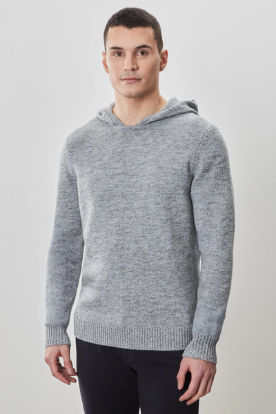 A person stands against a plain light background, facing forward with a neutral expression, wearing dark pants and the Robert Barakett Wildman Sweater by Robert Barakett in light gray.