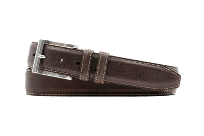 The Martin Dingman Bill Water Buffalo Leather Belt, handcrafted in the USA, features brown leather, white stitching, and a silver buckle. Buckle and holes are visible in the coiled belt.