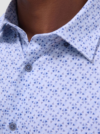 Close-up of a person wearing the Bugatchi LS Jules GF9090K65 Air Blue shirt—a light blue, geometric-patterned men’s dress shirt made from premium European fabrics by Bugatchi.