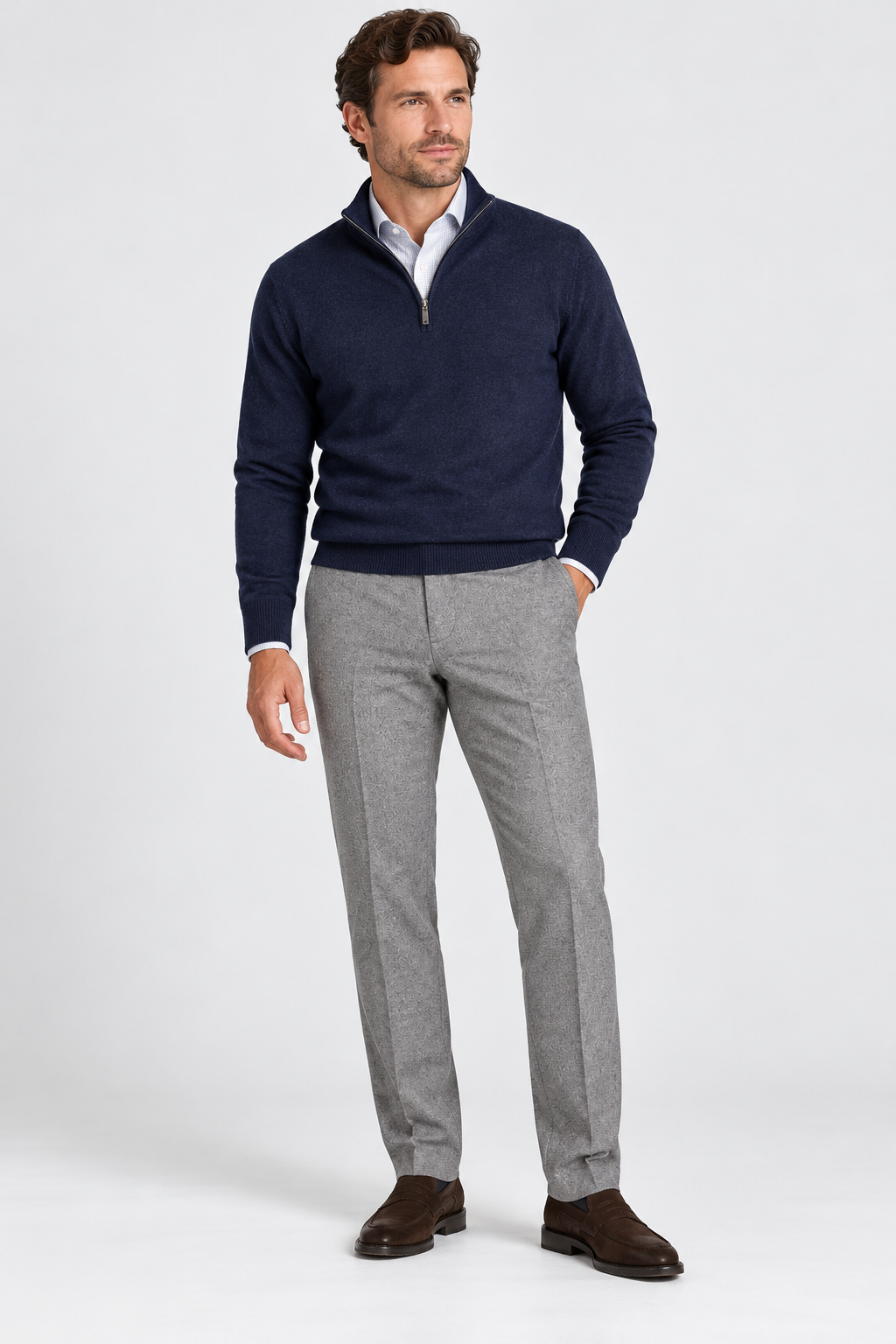 A man wearing a navy blue quarter-zip sweater over a white collared shirt, gray Alberto Lou Pant 1651 trousers, and brown loafers.