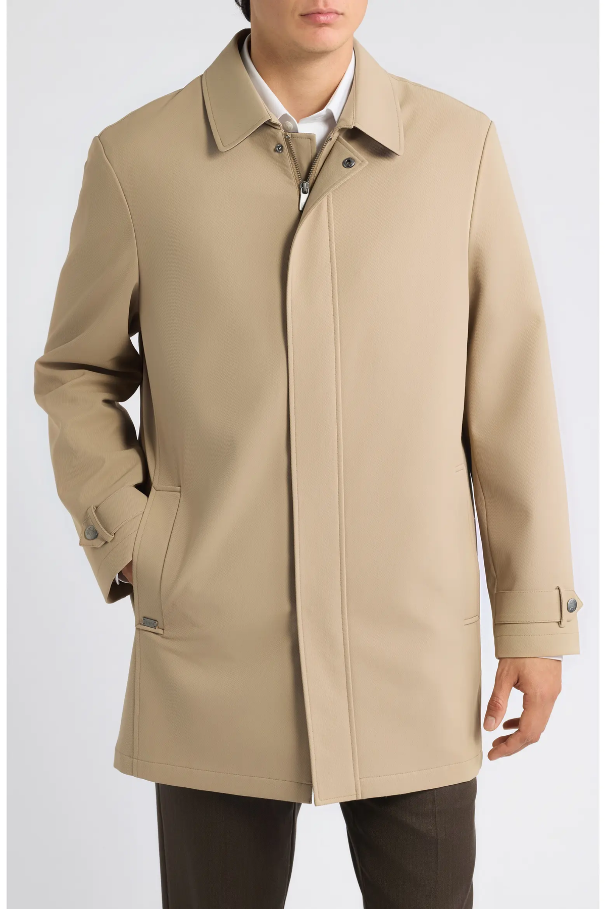 A beige Hart Schaffner Marx Milo Waterproof All-Weather Jacket featuring a collared neckline, a buttoned storm flap over the zipper, and tabbed cuffs.
