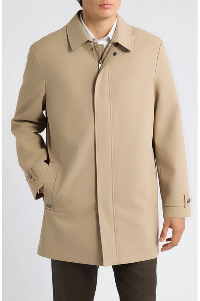 A beige Hart Schaffner Marx Milo Waterproof All-Weather Jacket featuring a collared neckline, a buttoned storm flap over the zipper, and tabbed cuffs.