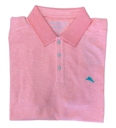 A folded pink Tommy Bahama Emfielder Island Zone Polo Big & Tall features a collar, three buttons, a small blue dolphin logo, and is crafted from moisture-wicking Supima cotton for comfort.
