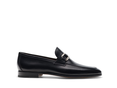 The Magnanni Silvano by Magnanni is a contemporary black leather strap loafer with a silver buckle, low heel, and stitched accents. Shown in profile on white, it's the ideal comfortable dress shoe.