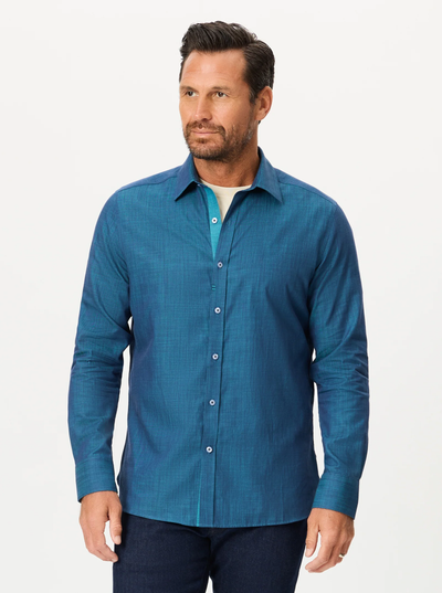 A man with short dark hair and a beard is wearing the Robert Graham Kerrington Woven Shirt Big & Tall—a teal, textured chambray sport shirt—paired with dark pants, standing against a plain white background.