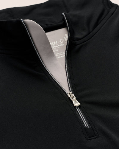 Close-up of the Johnnie-O Motion Big & Tall 1/4 Zip Swtr in black, featuring a silver zipper, light grey inner lining, and a visible part of the garment label.