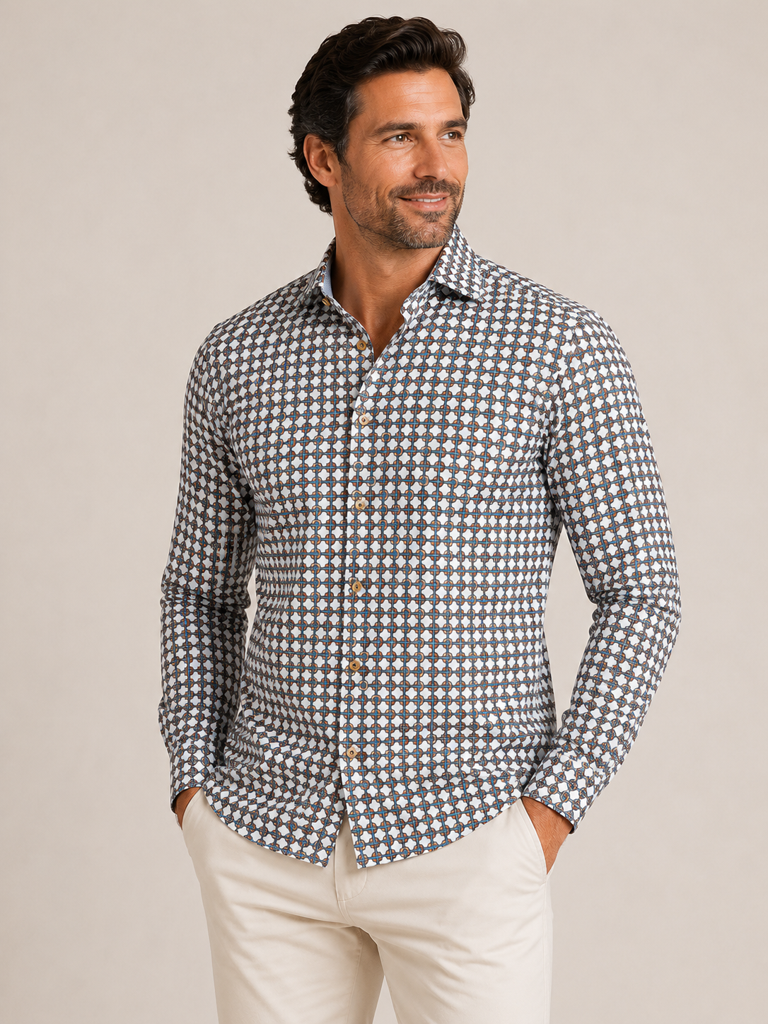Man wearing the Stone Rose Rings & Ropes RNRLSW52 long sleeve shirt, a blue and white geometric pattern shirt by Stone Rose, paired with light-colored pants and standing against a plain background.
