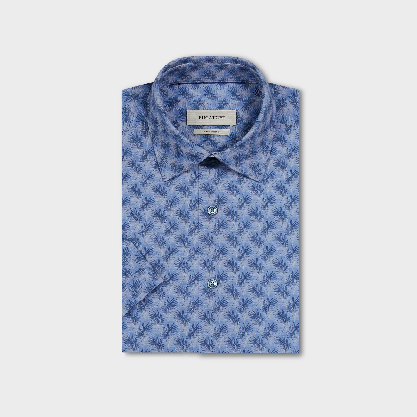 The Bugatchi Miles OoohCotton® Leaf Print Shirt JF9138F40 features a folded blue design with a dark leaf pattern and inner Bugatchi label, crafted from wrinkle-resistant performance fabric and shown on a plain background.